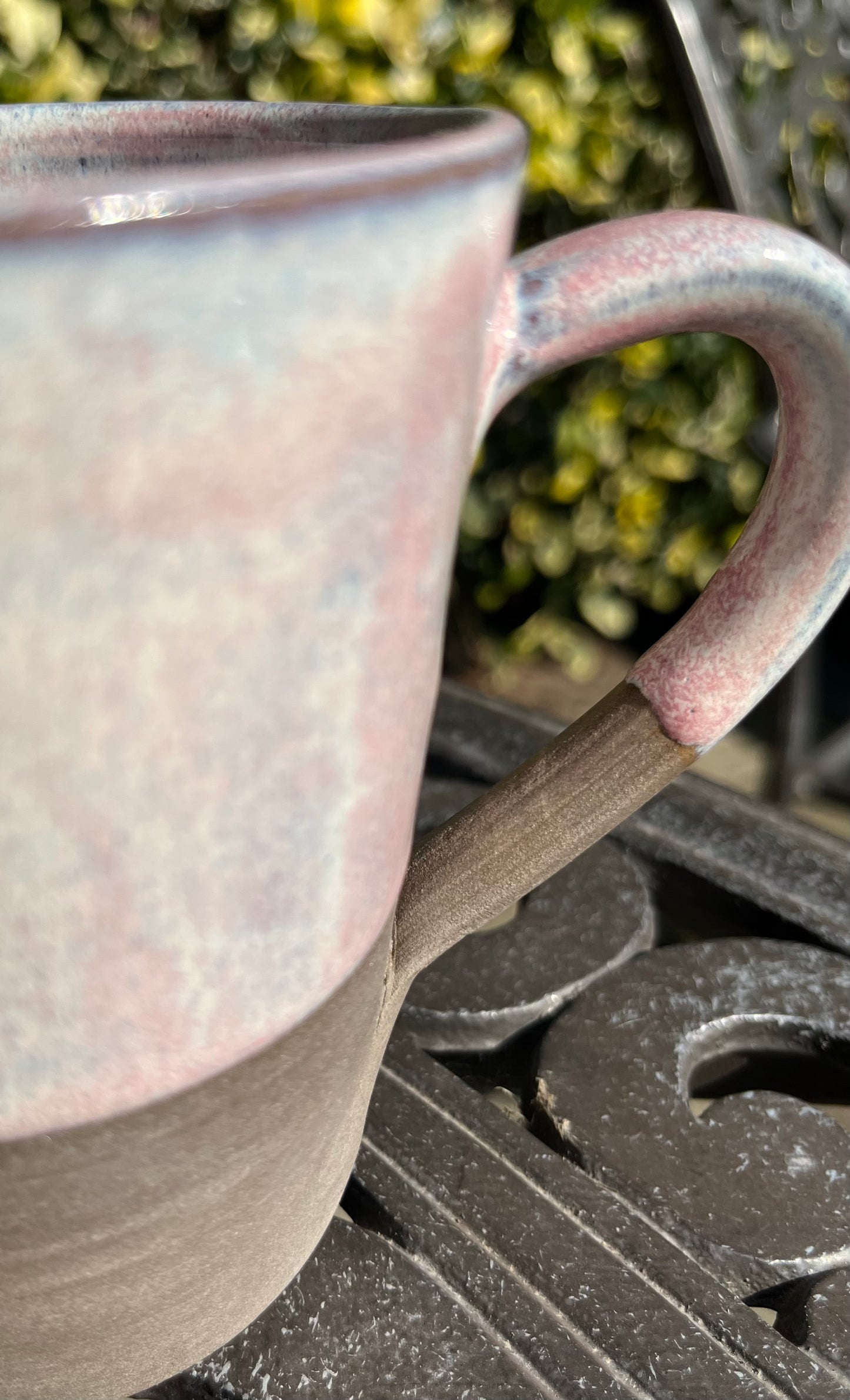 Misty pink glazed mug on dark clay
