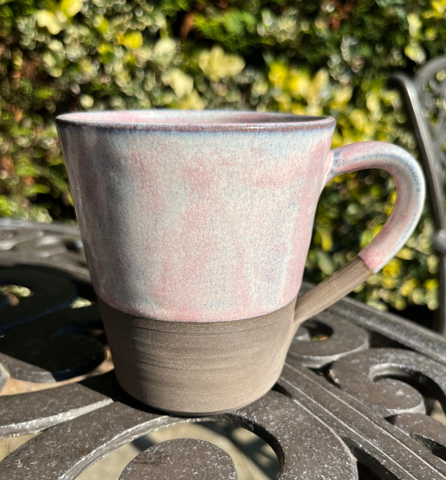 Misty pink glazed mug on dark clay