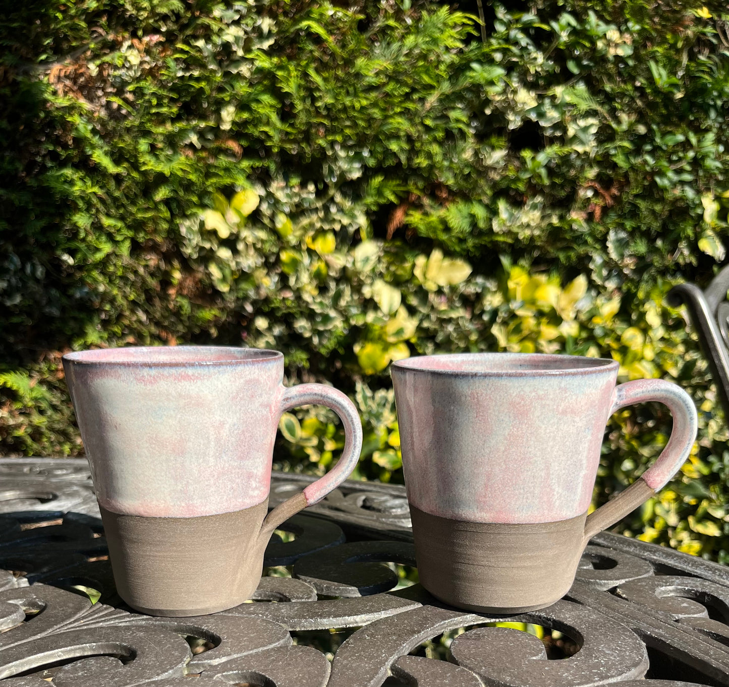 Misty pink glazed mug on dark clay